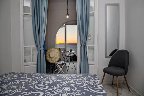 a bedroom with a bed and a view of the ocean at SUN AND SEA COTTAGE in Tinos