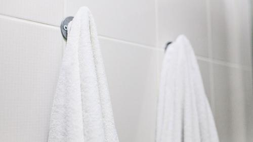 a white towel hanging on a wall in a shower at Royalton Inn and Suites, Wilmington,Ohio in Wilmington