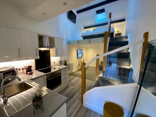 a kitchen with a staircase leading up to a loft at King Street Serviced Apartments in Lancaster
