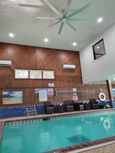 a swimming pool with a ceiling fan and chairs at Whitefish Lake Home with Heated Indoor Pool in Manhattan Beach