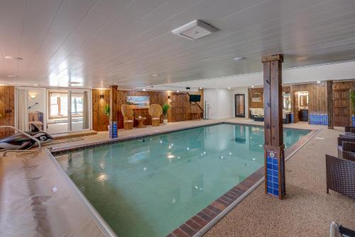 a large swimming pool in a hotel room at Whitefish Lake Home with Heated Indoor Pool in Manhattan Beach
