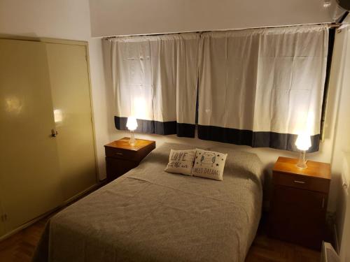 una camera da letto con un letto con due lampade sopra di departamento de Emiko a Córdoba