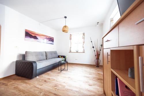 a living room with a couch and a tv at Pension-Cafe-Konditorei Mikl in Hallein