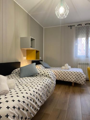 a bedroom with two beds and a chandelier at Apartamento Rural El Retablo in Cetina