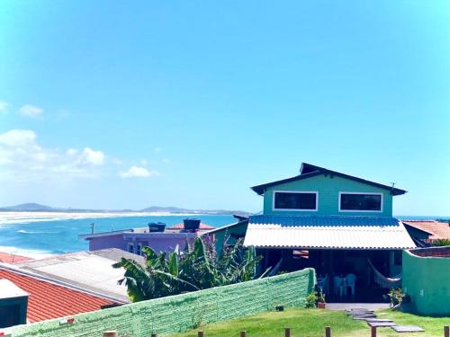 a house on the beach with the ocean in the background at Chalês Santa Marta in Farol de Santa Marta