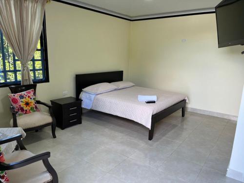 1 dormitorio con 1 cama y 1 silla en Alojamiento Rural Casa de Campo Erika Sofia, en Rivera