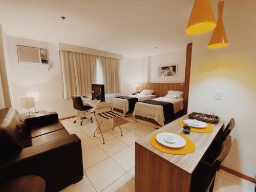 uma sala de estar com uma cama e uma sala de jantar em Suíte completa no centro (SOHO Campos) em Campos dos Goytacazes