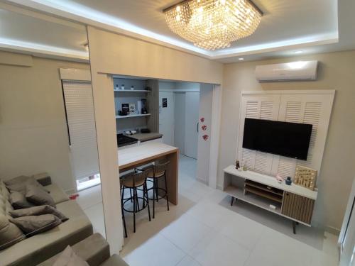 sala de estar con sofá y cocina con TV en Apartamento Pé na Areia, en Florianópolis