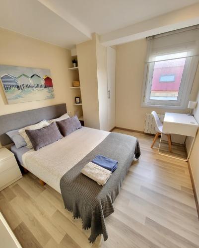 Schlafzimmer mit einem Bett, einem Schreibtisch und einem Fenster in der Unterkunft Tranquilidad cerca de la playa... para vivir la ciudad in A Coruña