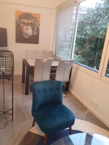 une salle à manger avec une table et une chaise bleue dans l'établissement Bel Apt Near Croisette Beach Cannes, à Cannes