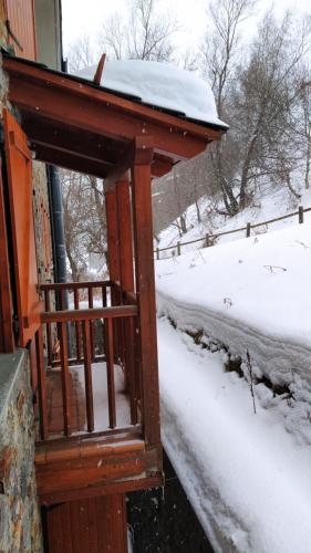 a woodenshed with snow on the roof of a house at SOLDEU cosy home in Soldeu