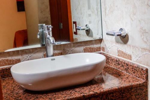 lavabo blanco en la encimera del baño en Motel Primavera en Guadalajara