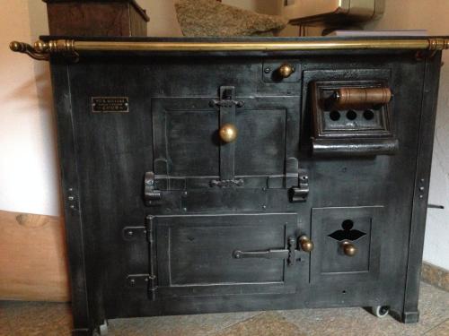 an old black woodburning stove in a room at Hotel Saluver in Celerina
