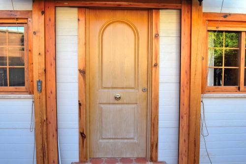 una puerta de madera en una casa con 2 ventanas en Coqueta casita de 2 habitaciones, en La Manga del Mar Menor