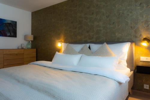 a bedroom with a large bed with white pillows at Bergzeit Gosau in Gosau
