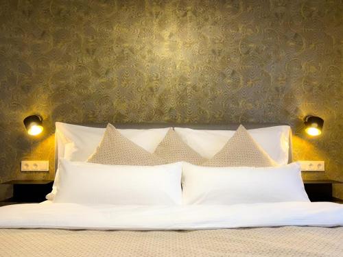 - un lit avec des oreillers blancs dans une chambre dans l'établissement Bergzeit Gosau, à Gosau