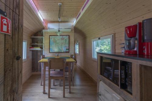 a dining room and kitchen in a tiny house at Bij grenspaal 243 in Essen