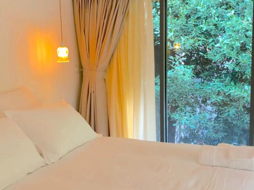 een slaapkamer met een wit bed en een raam bij Les Nuits Pétillantes in Cournonterral