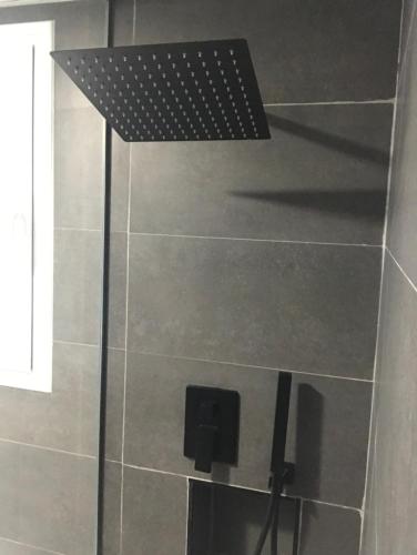 a shower with a black shower head in a bathroom at Suite Vitbanus in Marbella