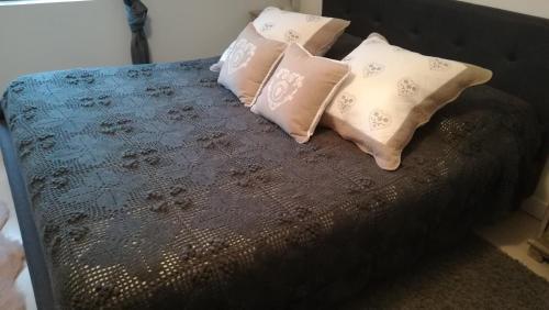 a bed with four pillows on top of it at La Gerbaudiere Chambres&Table d hotes proche Mont Saint Michel CUISINE MAISON in Notre-Dame-du-Touchet