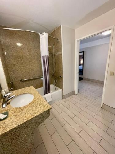 a bathroom with a sink and a shower and a tub at La Quinta by Wyndham Bakersfield North in Bakersfield