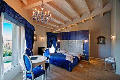 une chambre d'hôtel avec un lit, une table et des chaises dans l'établissement Boutique Hotel Calzavecchio, à Casalecchio di Reno
