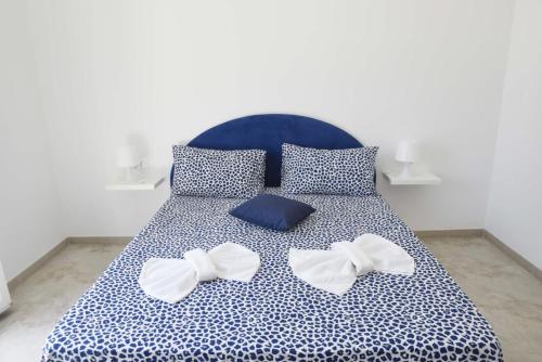 un letto con lenzuola blu e bianche con inchini di La casa del Gabbo apartment a Monopoli