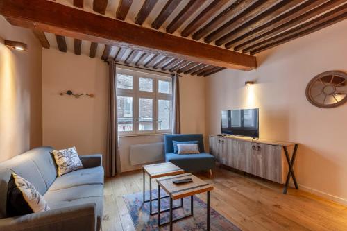 a living room with a couch and a tv at La Cachette de Lucie - center of Honfleur - 100m from the Port - 2P in Honfleur