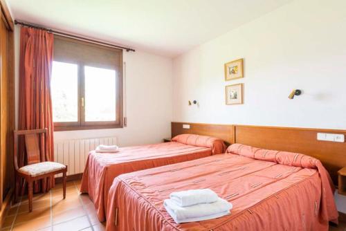 a hotel room with two beds and a window at Apart-Hotel Selva Nevada in La Virgen de la Vega