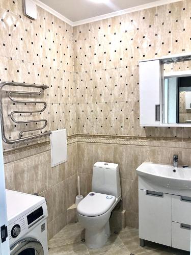 a bathroom with a toilet and a sink at Уютная квартира с новым ремонтом in Leninskoye