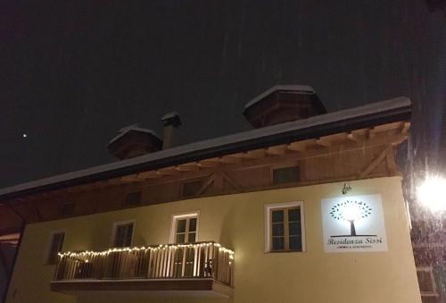 a building with a sign on the side of it at night at Bed & Breakfast SISSI in Commezzadura