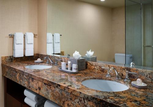 a bathroom with two sinks and a large mirror at Little America Hotel Salt Lake City in Salt Lake City