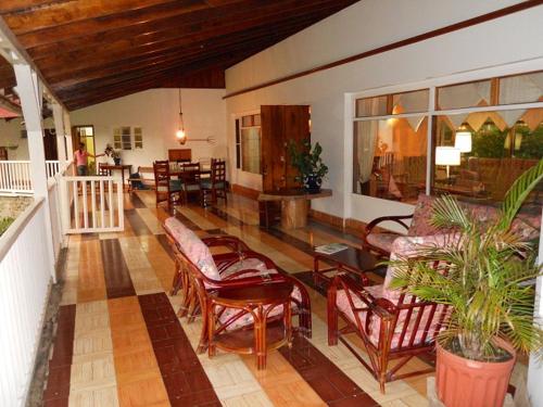 un soggiorno con un mucchio di sedie e tavoli di Casa Romero - A cozy tradition a Boquete