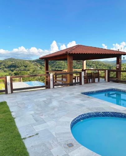 a patio with a gazebo and a swimming pool at Pousada Yvanna in Pirenópolis