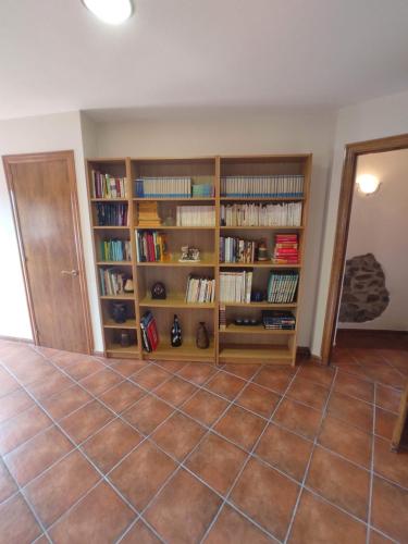 a room with wooden book shelves with books at Cal Ferrer in Poboleda