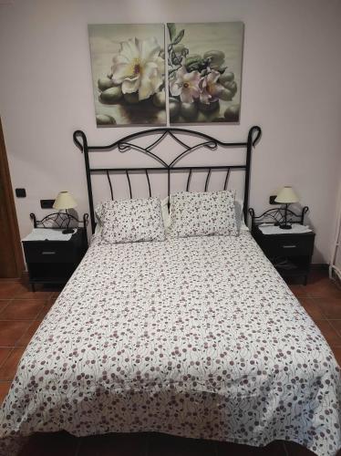 1 dormitorio con 1 cama con edredón blanco y negro en Cal Ferrer, en Poboleda