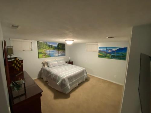 1 dormitorio con 1 cama y cuadros en las paredes en Salt Lake City Sweet Spot, en Murray