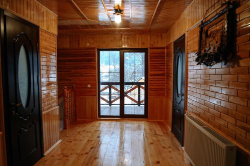 een lege kamer met een groot raam en houten wanden bij Котедж «Медовий сад» in Verkhovyna