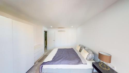 een slaapkamer met een bed in een witte muur bij Las Palmeras - Best Location Cozy Apartment in Fuengirola