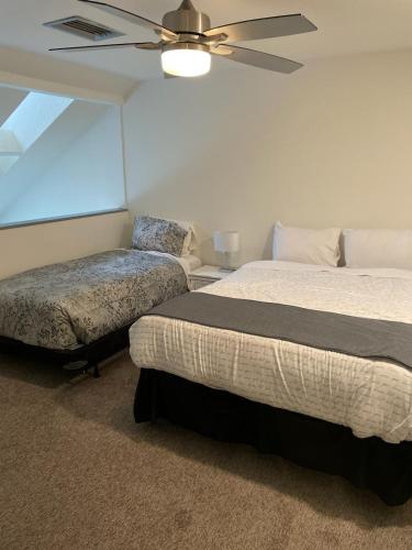 a bedroom with two beds and a ceiling fan at Hearthstone Lodge loft, Village centre, Private Hot tub, sleeps 6 in Whistler
