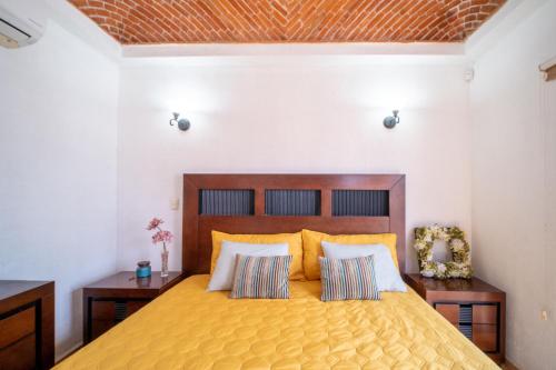 1 dormitorio con 1 cama amarilla y 2 almohadas en PENINSULA STAYS 3 BR House & AC + Private Parking + FAST WIFI, en Chetumal