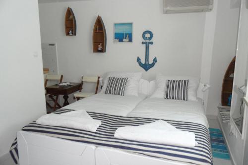 Cama blanca con manta de rayas azul y blanca en Room Leon, en Split