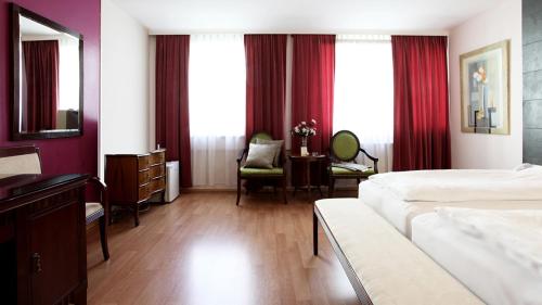um quarto de hotel com uma cama, uma secretária e janelas em Hotel Attaché contactless em Viena