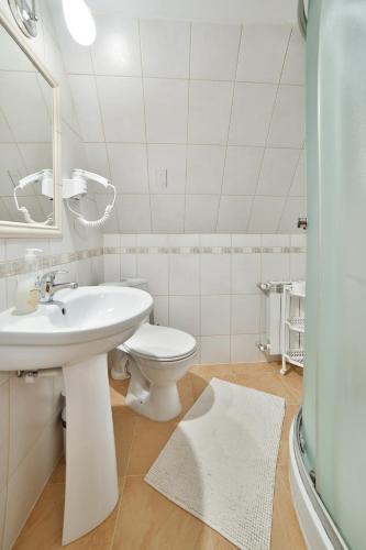 a white bathroom with a sink and a toilet at Willa Jarząbek - 5 min do term Szaflary I Gorący Potok in Szaflary