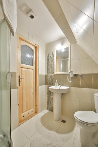 a white bathroom with a sink and a toilet at Willa Jarząbek - 5 min do term Szaflary I Gorący Potok in Szaflary