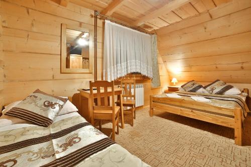 a bedroom with two beds and a desk and a table at Willa Jarząbek - 5 min do term Szaflary I Gorący Potok in Szaflary