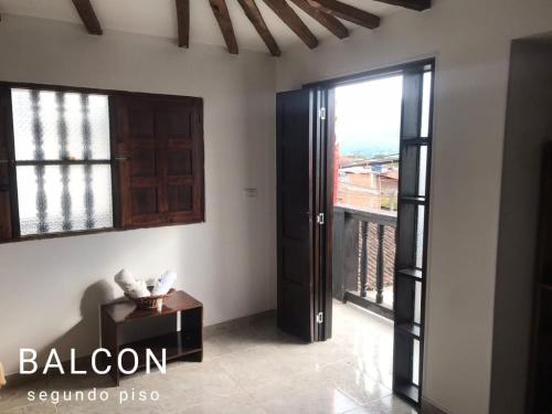 a room with a door and a table and a balcony at Hostal Diana in San Agust&iacute;n