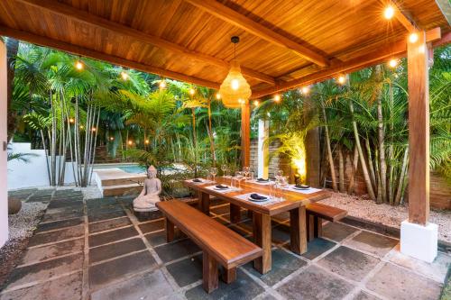 an outdoor dining area with a wooden table and benches at Cafe Playa Negra Hotel in Playa Negra