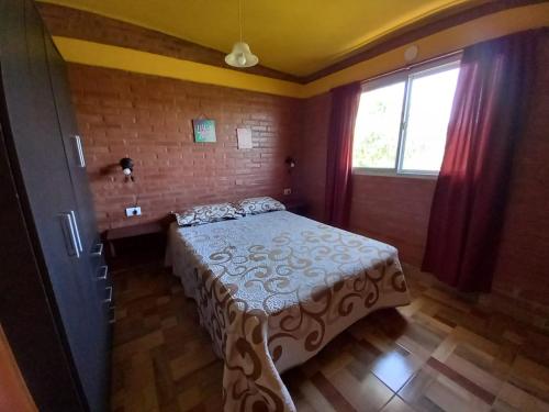 un dormitorio con una cama y una ventana en Departamentos Las Marias, en Villa Cura Brochero