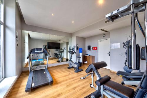 a gym with treadmills and exercise equipment in a room at Radisson BLU Balmoral in Spa